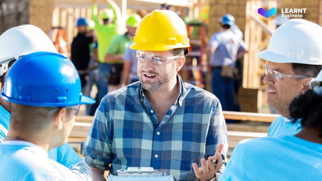 A construction supervisor discussing site training and safety compliance with workers, ensuring workforce efficiency and compliance with industry standards.