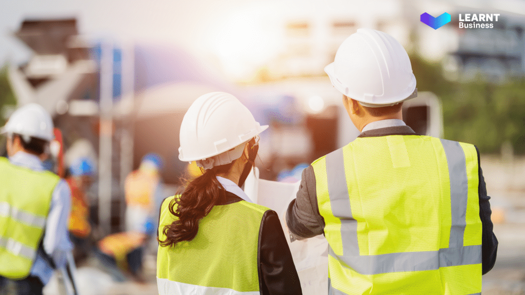 Construction supervisors reviewing project plans at a job site.
