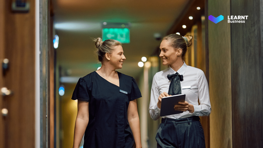 A hotel supervisor conducting a compliance training session with a housekeeping staff member.